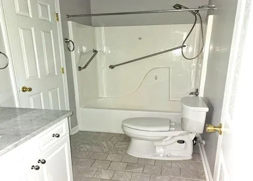 a white toilet sitting next to a bathroom sink and shower