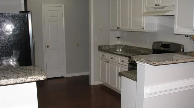 a kitchen with granite countertop cabinets and stove top oven