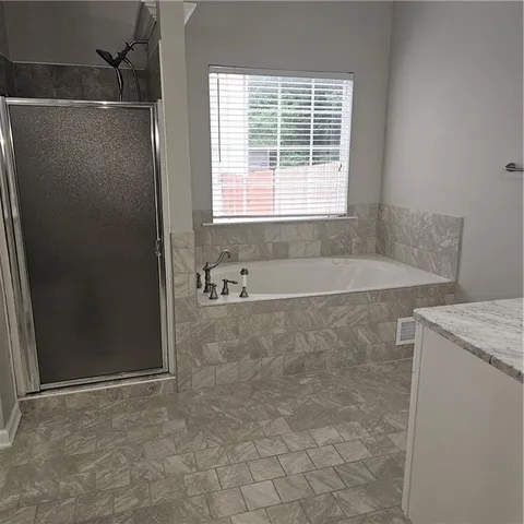 a bathroom with a shower and a bath tub