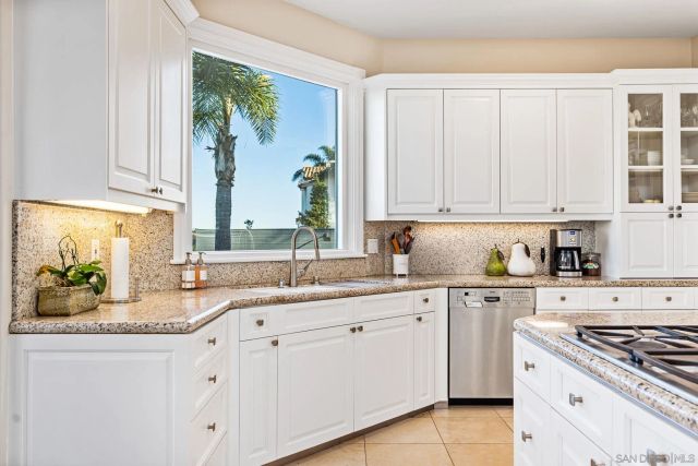 a kitchen with stainless steel appliances kitchen island a refrigerator sink and cabinets