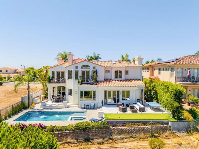 a view of a house with swimming pool and sitting area