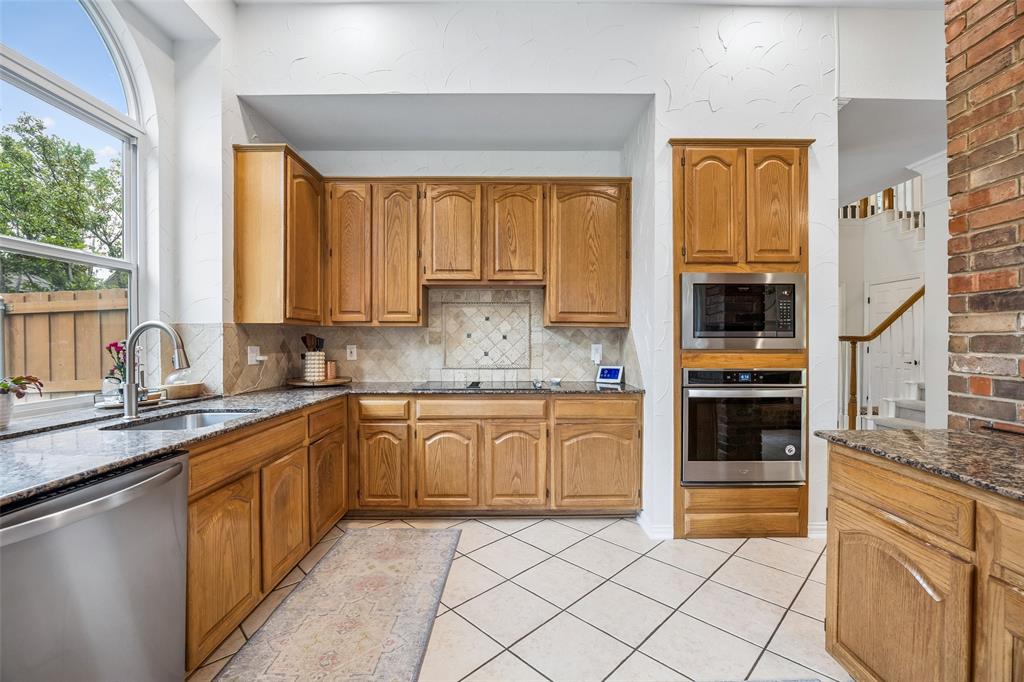 5511 South Briar Ridge Circle McKinney, TX 75072 - Photo 18 of 35 a kitchen with stainless steel appliances granite countertop a stove a sink and a microwave
