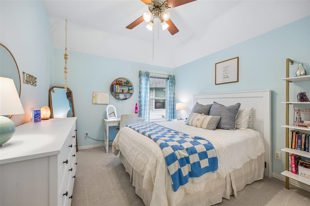 5511 South Briar Ridge Circle McKinney, TX 75072 - Photo 22 of 35 a bedroom with a bed and a chandelier