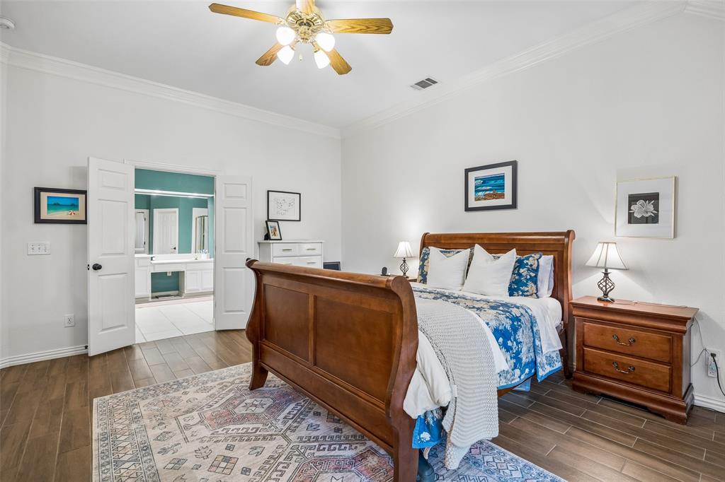 5511 South Briar Ridge Circle McKinney, TX 75072 - Photo 4 of 35 a bedroom with a bed and a chandelier