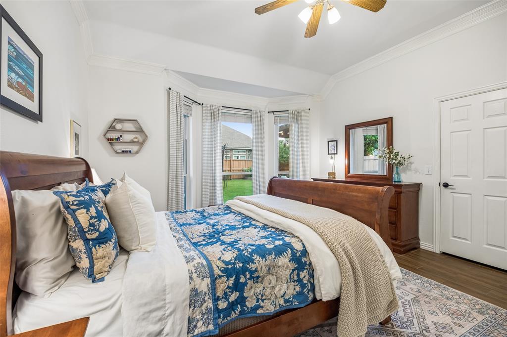 5511 South Briar Ridge Circle McKinney, TX 75072 - Photo 5 of 35 a bedroom with a bed and a chandelier