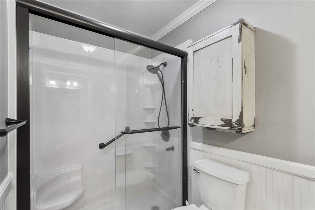 1211 Melbourne Drive Anderson, SC 29621 - Photo 26 of 35 This bright bathroom features a glass-enclosed shower and practical wall-mounted storage.
