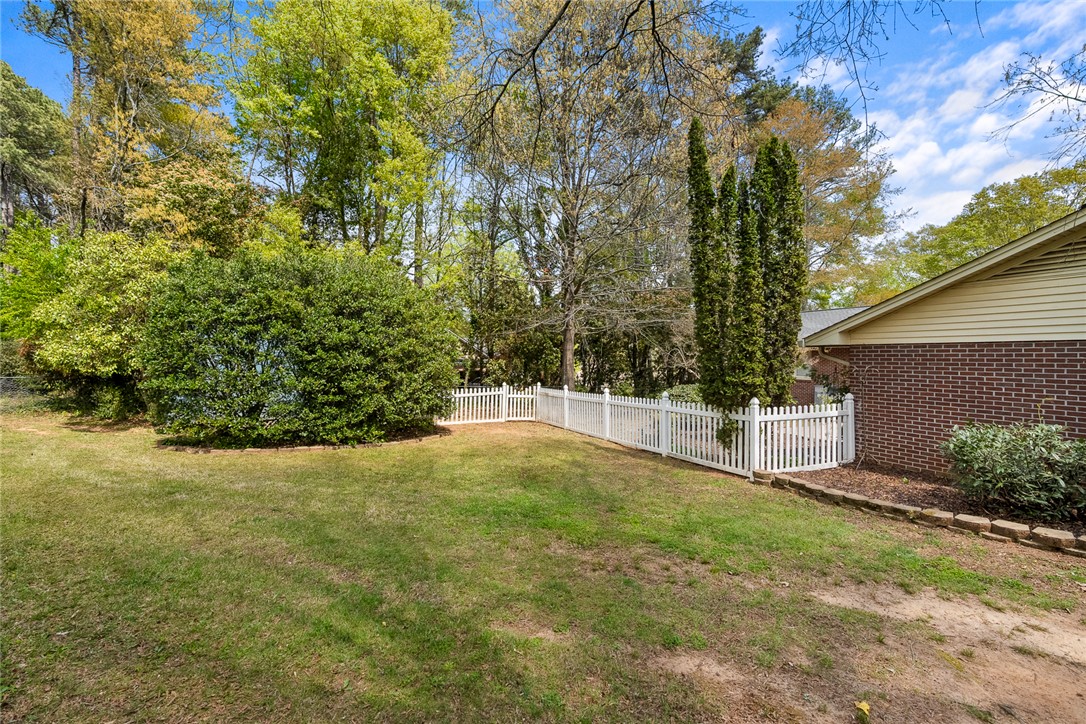 1211 Melbourne Drive Anderson, SC 29621 - Photo 33 of 35 This private yard features mature trees, manicured shrubs, and a charming picket fence.