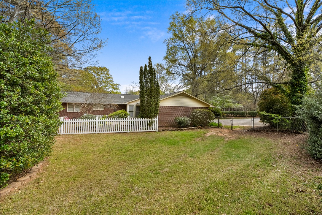 1211 Melbourne Drive Anderson, SC 29621 - Photo 34 of 35 This charming residence features a well-maintained lawn, a white picket fence, and mature landscaping.
