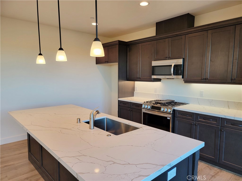 725 Manor Lane Paso Robles, CA 93446 - Photo 6 of 29 a kitchen with a stove a sink and a refrigerator