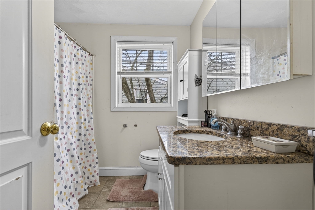 74 Linwood Street Lynn, MA 01905 - Photo 13 of 37 a bathroom with a granite countertop sink a mirror a toilet and a shower