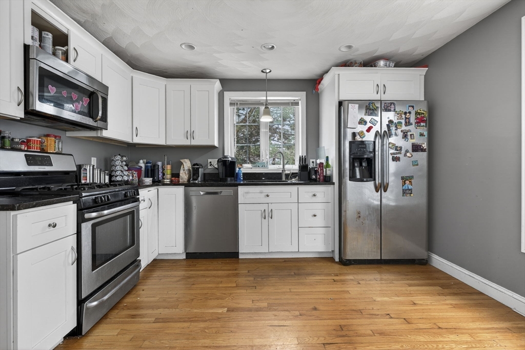 74 Linwood Street Lynn, MA 01905 - Photo 3 of 37 a kitchen with stainless steel appliances granite countertop a stove a sink and a refrigerator