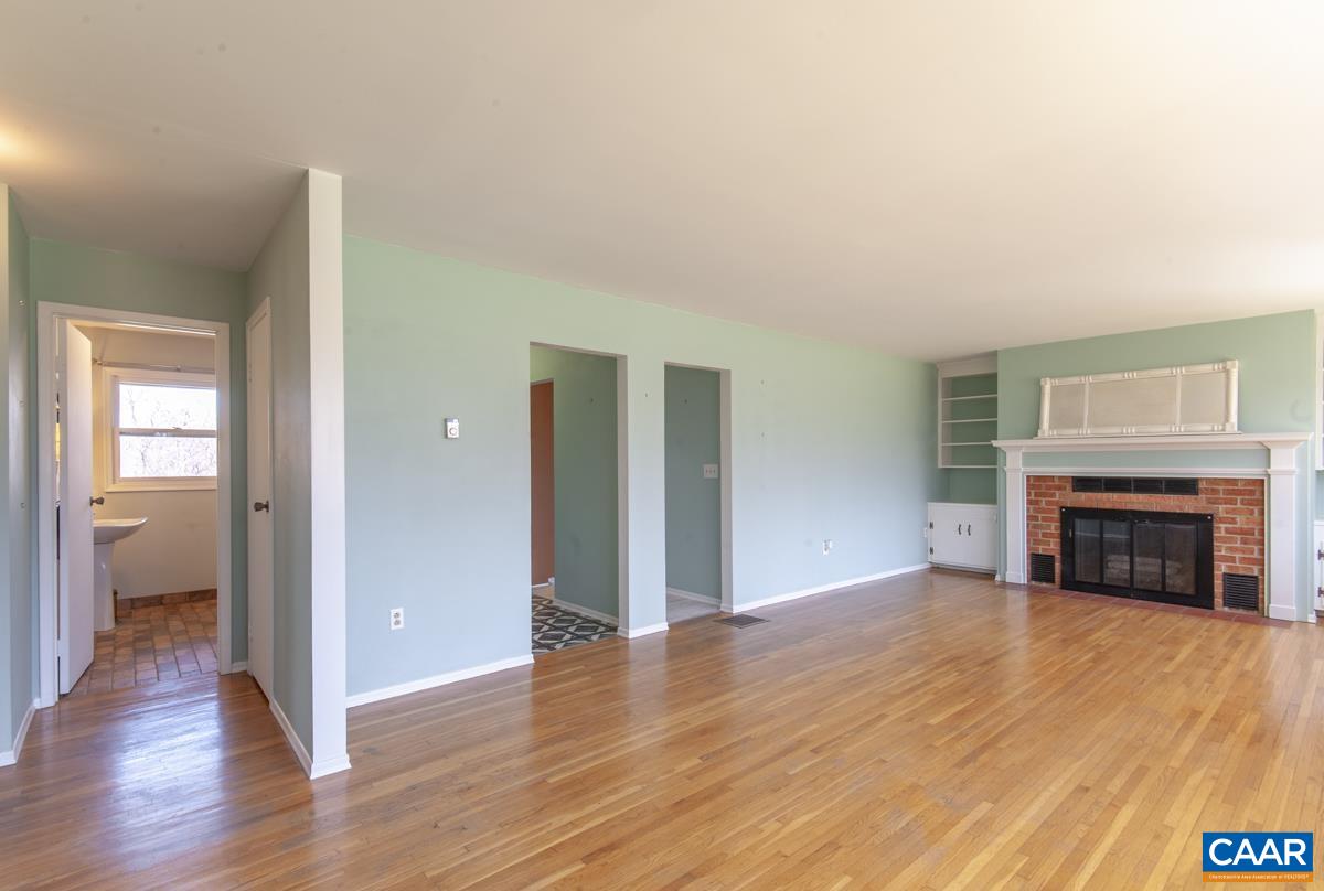 801 Poplar Spring Road Scottsville, VA 24590 - Photo 2 of 44 a view of an empty room with wooden floor fireplace and a window