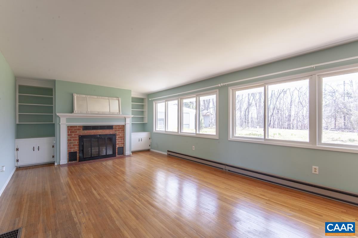 801 Poplar Spring Road Scottsville, VA 24590 - Photo 3 of 44 wooden floor fireplace and windows in an empty room