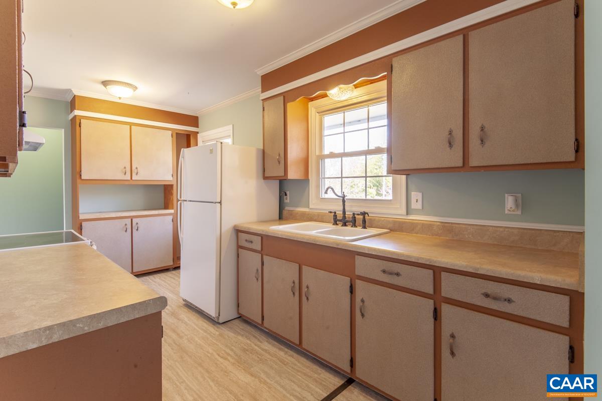 801 Poplar Spring Road Scottsville, VA 24590 - Photo 8 of 44 a kitchen with a refrigerator sink and cabinets
