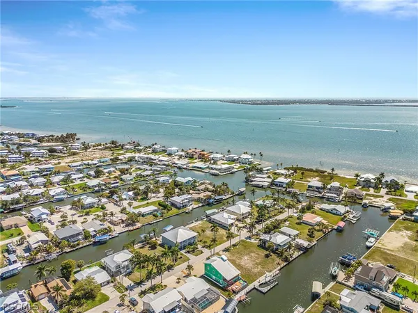 an aerial view of ocean and residential houses with outdoor space
