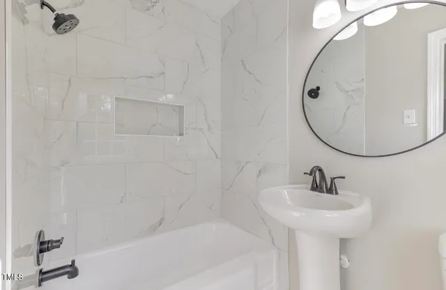 a bathroom with a sink a bathtub and a mirror