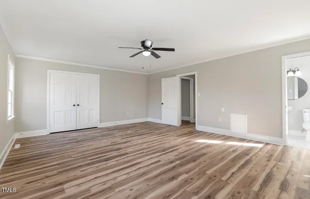 a view of empty room with wooden floor and ceiling fan