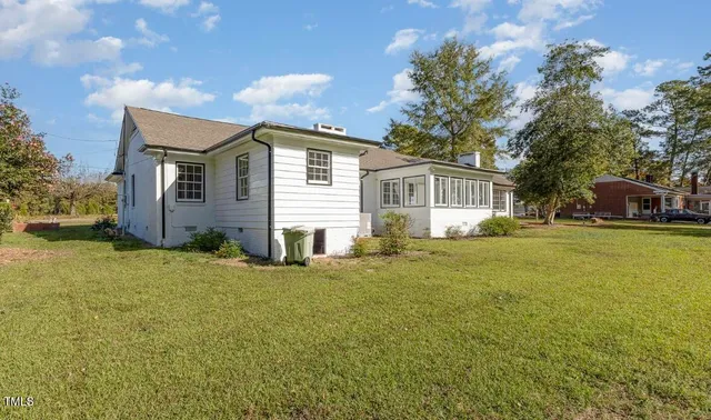 a front view of house with yard and trees in the background