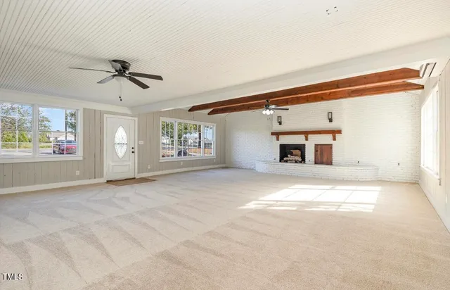 a view of a livingroom with a fireplace and a ceiling fan