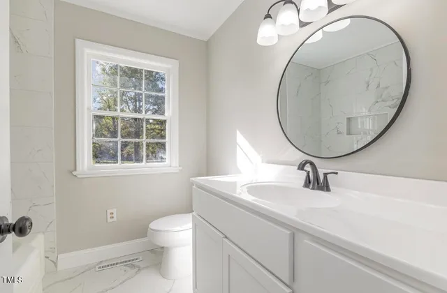 a bathroom with a sink a toilet and a mirror