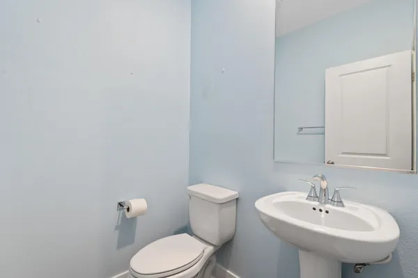 a bathroom with a sink a toilet and mirror