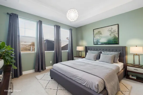 a bedroom with a large bed and a chandelier