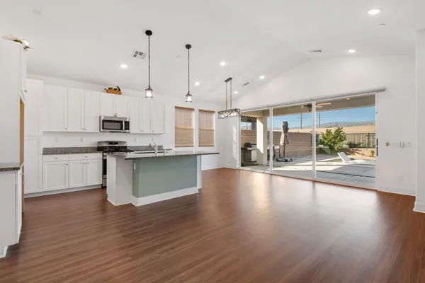 a kitchen with granite countertop a stove and a wooden floors