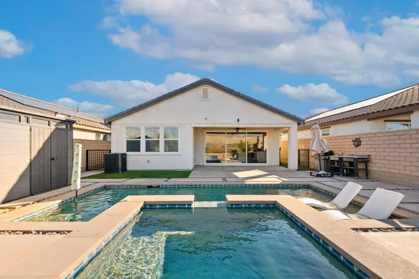 a view of a house with backyard and sitting area