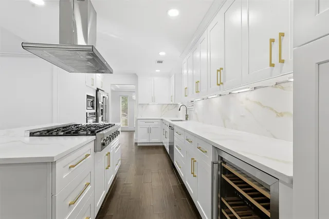 a kitchen with stainless steel appliances a stove and white cabinets