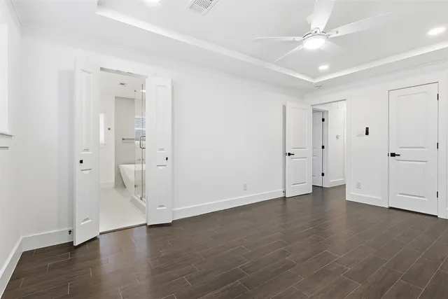 an empty room with wooden floor and ceiling fan