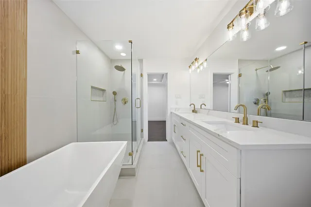 a spacious bathroom with a double vanity sink a mirror and a bathtub