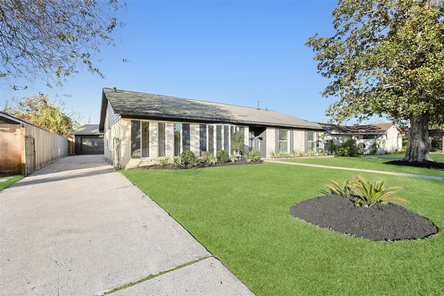 a view of a house with a big yard and a large tree