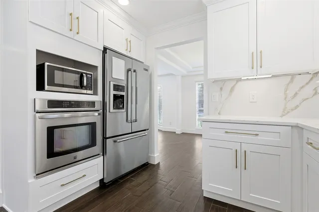 a kitchen with stainless steel appliances white cabinets and wooden floors