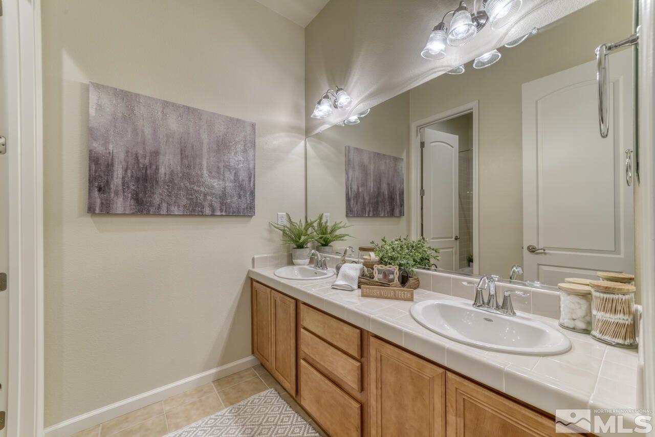 2604 Mule Circle Reno, NV 89521 - Photo 35 of 40 a bathroom with a sink a large mirror and a shower