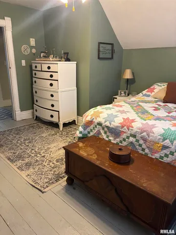 a view of a hallway with wooden floor and a livingroom