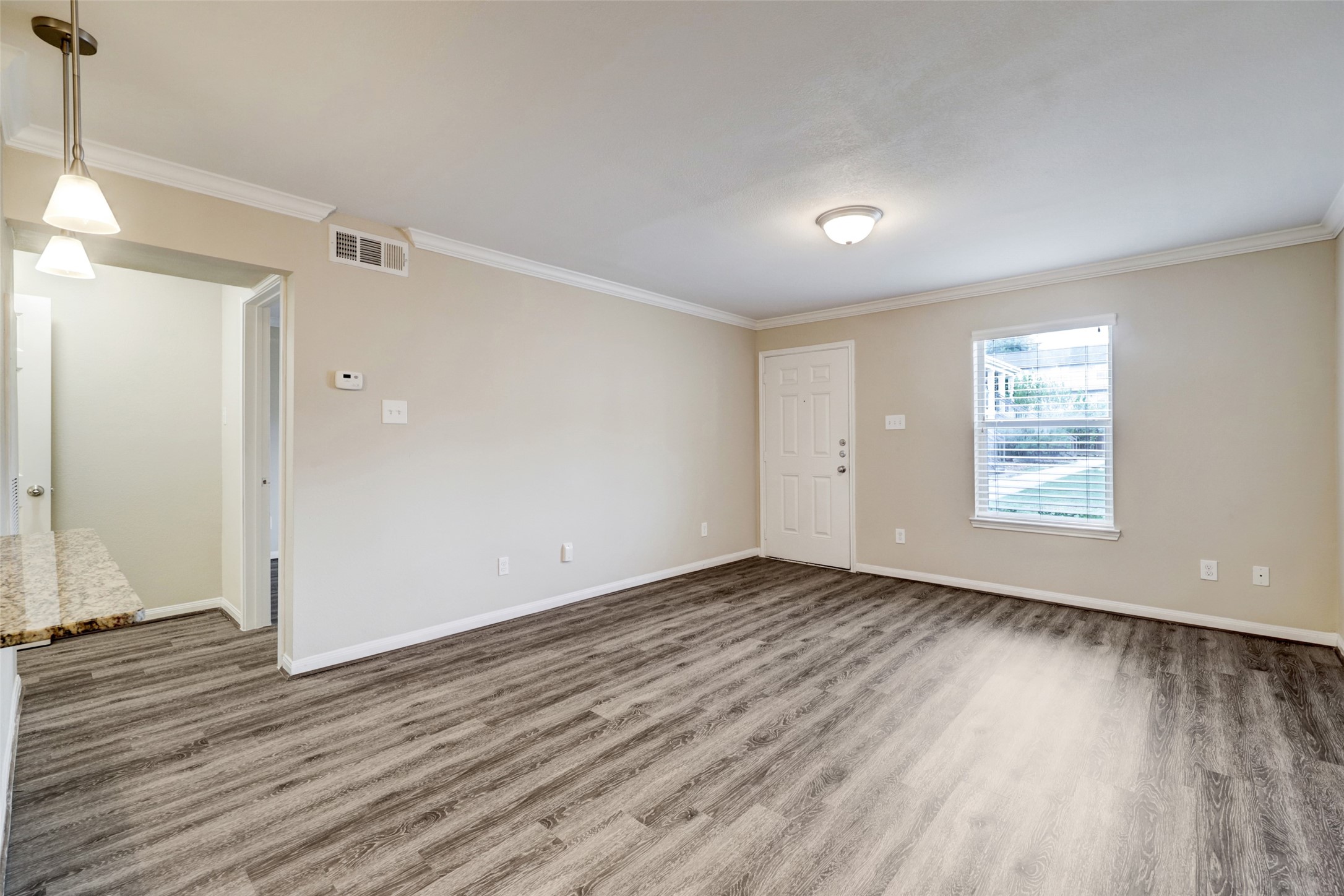 1600 West T C Jester Boulevard, Unit 14 Houston, TX 77008 - Photo 3 of 11 an empty room with wooden floor and windows