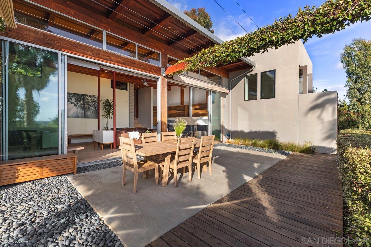 3545 Dove Hollow Road Encinitas, CA 92024 - Photo 52 of 69 a view of a patio with table and chairs with wooden floor and fence