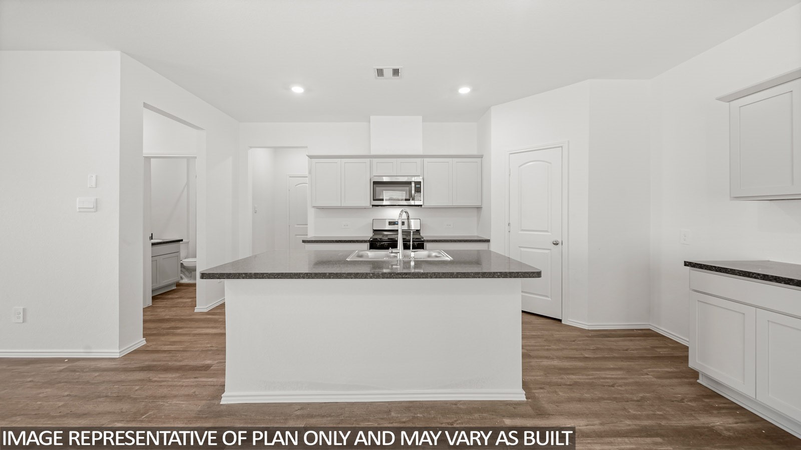125 Rising Cedar Lane Hockley, TX 77447 - Photo 3 of 19 a view of a kitchen with kitchen island a sink wooden floor and a refrigerator