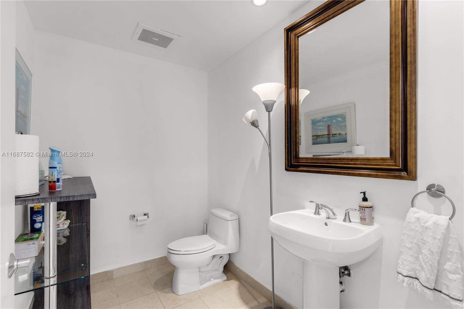 1060 Brickell Avenue, Unit 409 Miami, FL 33131 - Photo 11 of 25 a bathroom with a toilet sink and mirror