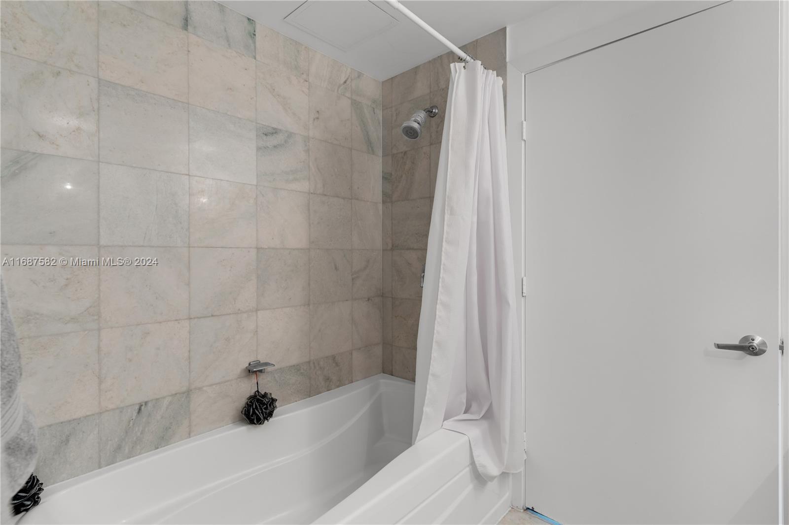 1060 Brickell Avenue, Unit 409 Miami, FL 33131 - Photo 12 of 25 a bathroom with a bathtub and a shower