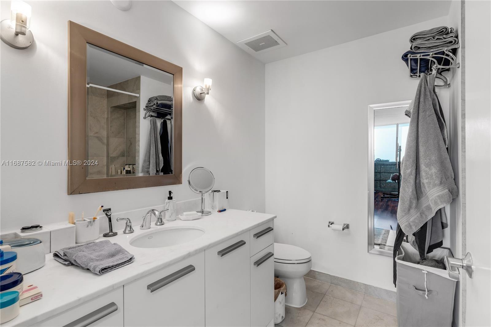 1060 Brickell Avenue, Unit 409 Miami, FL 33131 - Photo 10 of 25 a bathroom with a sink a toilet and a mirror