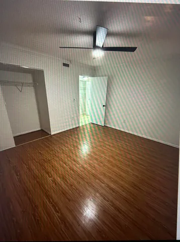 a view of an empty room with wooden floor