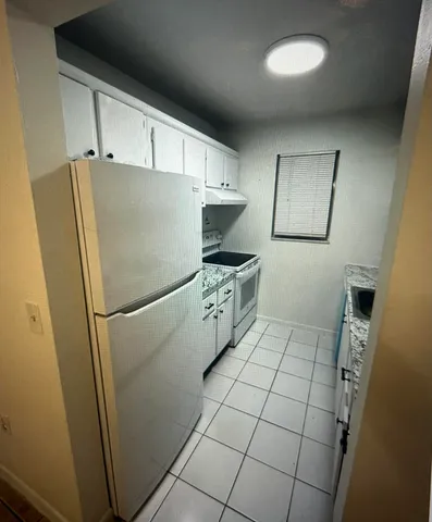 a white refrigerator freezer sitting inside of a kitchen