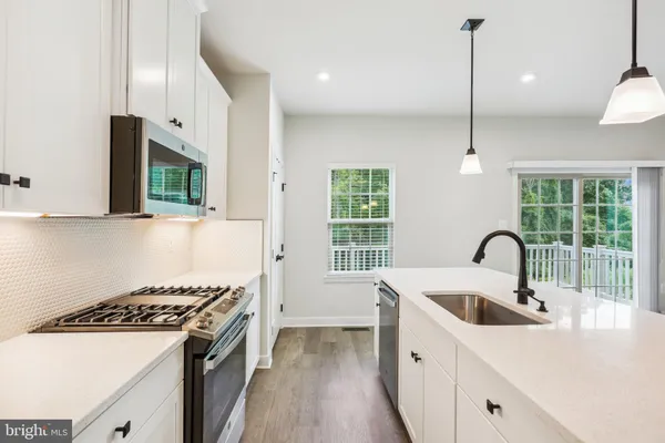 a kitchen with a sink a stove and cabinets