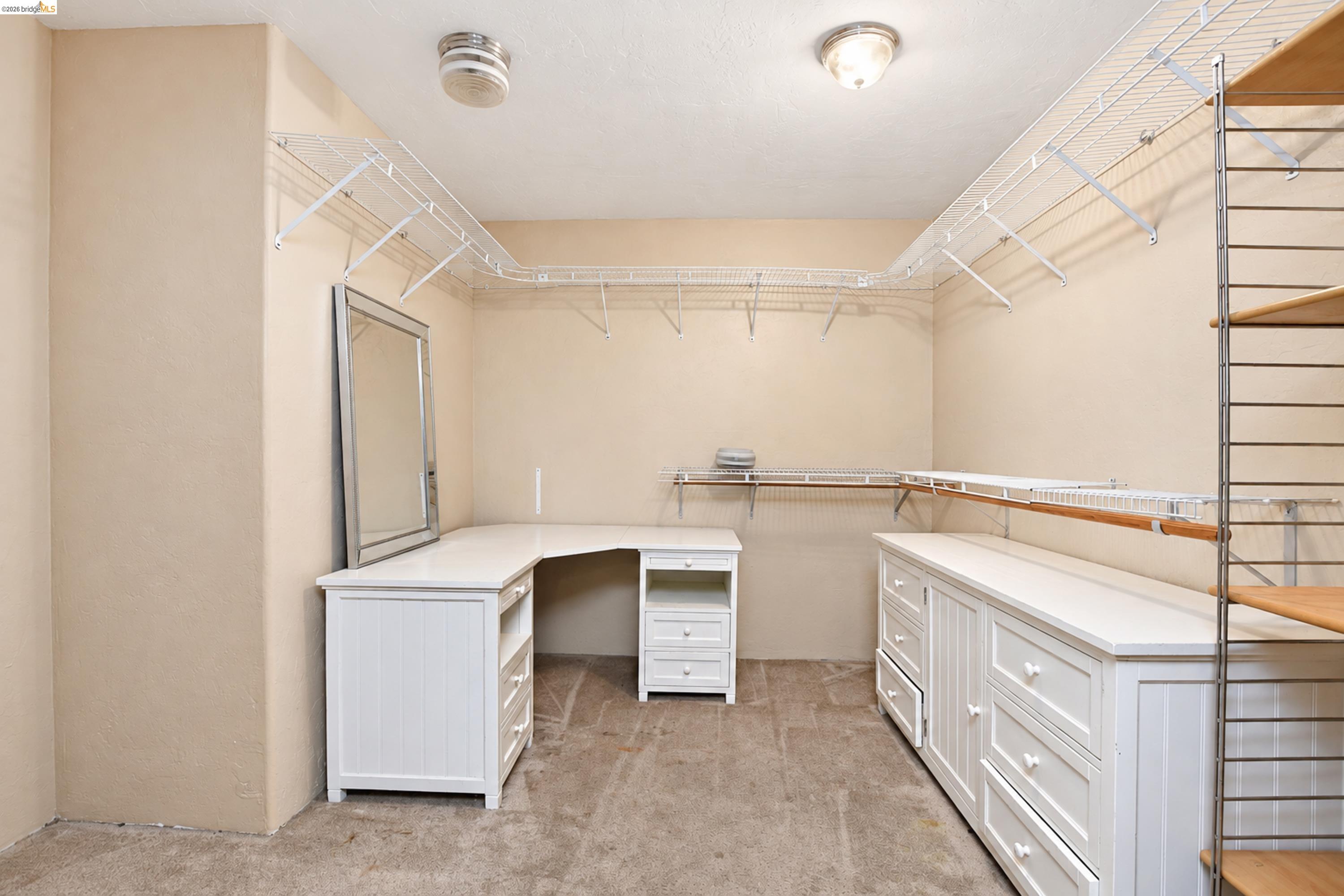 340 West Bolton Road Oakley, CA 94561 - Photo 83 of 87 Built-in closet organization system, white wood-finish cabinetry, wire shelving, wood-finish hanging rod, and wall-mounted light fixture