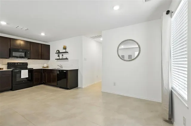 a kitchen with stainless steel appliances kitchen island granite countertop a refrigerator and a sink