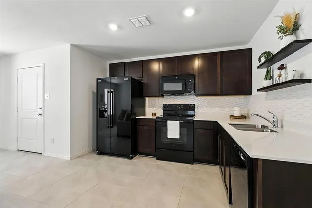 a kitchen with stainless steel appliances a sink stove and cabinets