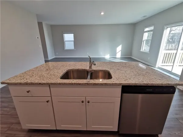 a kitchen with granite countertop a sink and cabinets