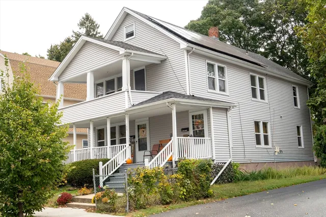 a front view of a house with a yard and potted plants