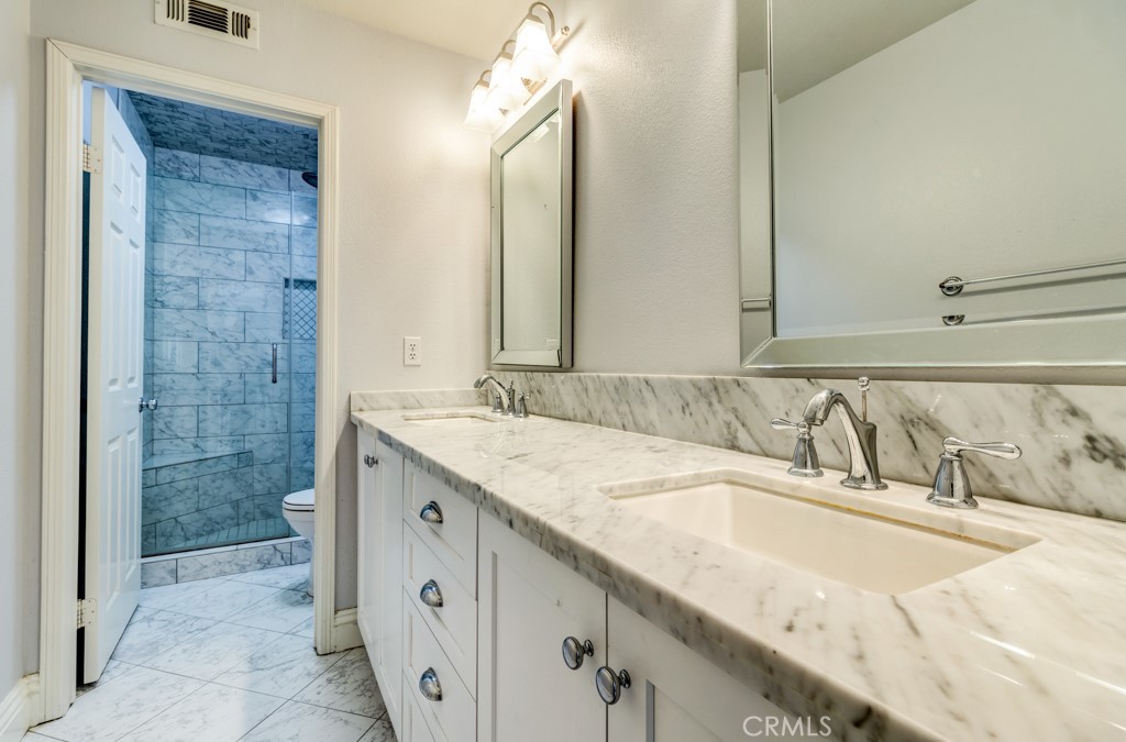 8 Zinnia Irvine, CA 92618 - Photo 29 of 39 a bathroom with a granite countertop sink and a mirror